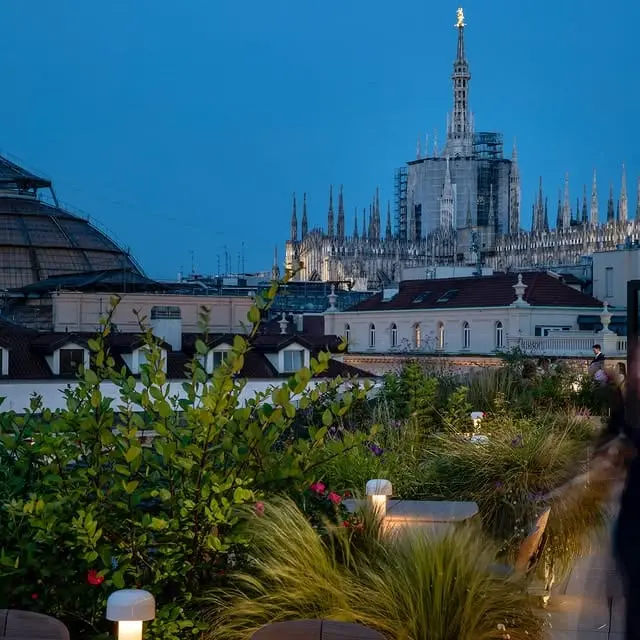 Il giardino in terrazza all'imbrunire, con il Duomo illuminato sullo sfondo